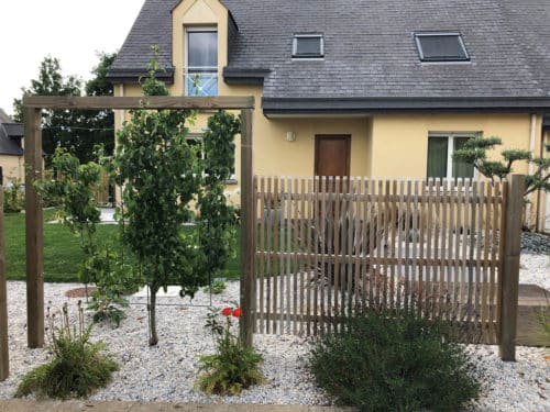 Clôture ajourée en bois avec structure grimpante en bois