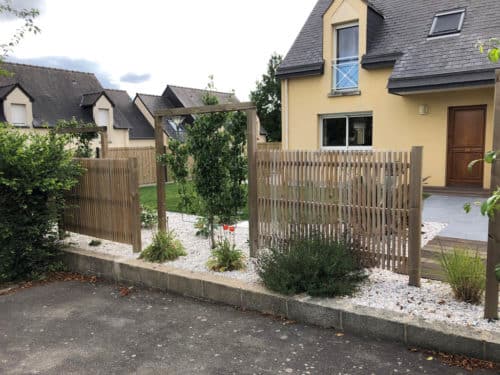 Clôture ajourée en bois avec structure grimpante en bois