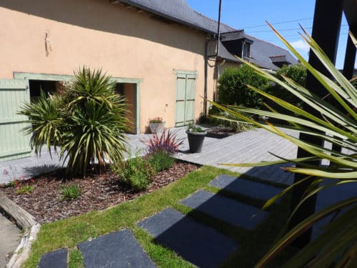 Terrasse en bois exotique avec une allée de pas japonais en ardoise