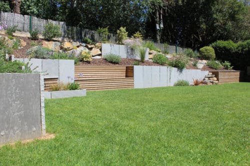 Soutènement en grès gris, en enrochement et en bardage bois