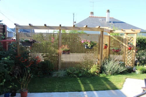 Pergola brise-vue en bois avec un massif